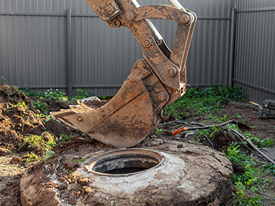 Excavator bucket above septic tank